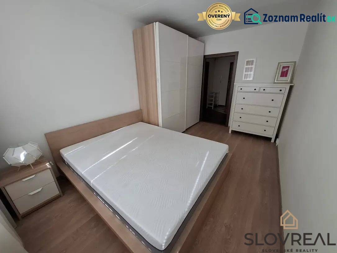 Schlafzimmer in einer 3-Zimmer-Wohnung mit Holzboden, Bett und weißen Möbeln.
