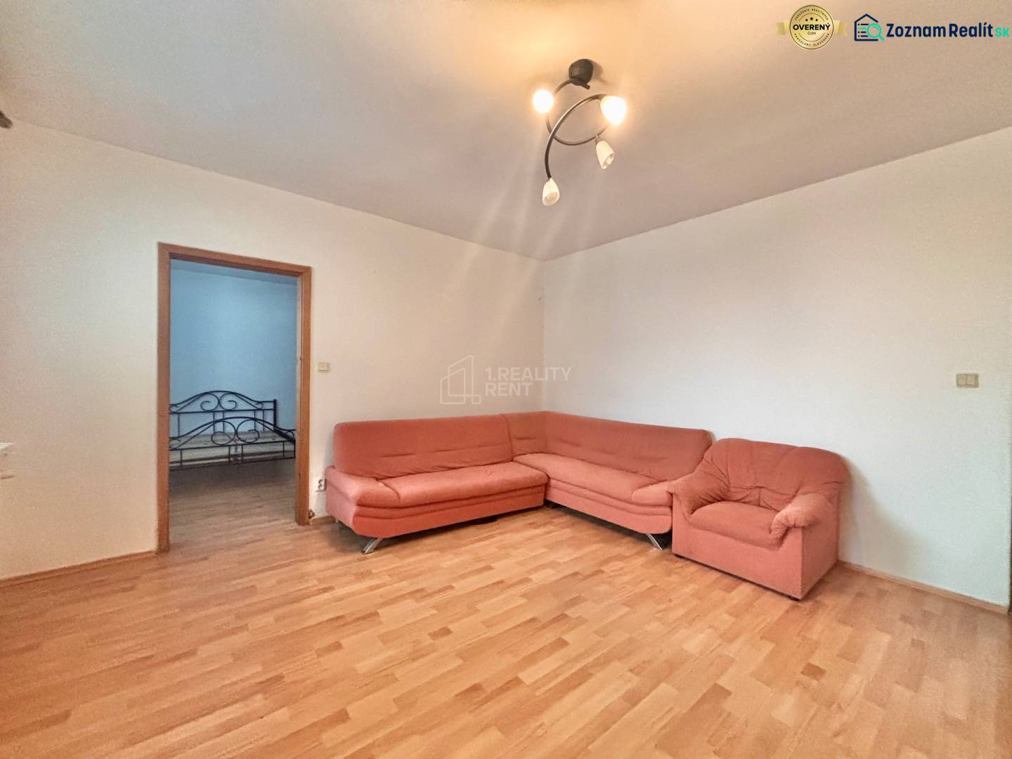 Wohnzimmer in einer 3-Zimmer-Wohnung mit Holzboden und einem orangefarbenen Sofa.