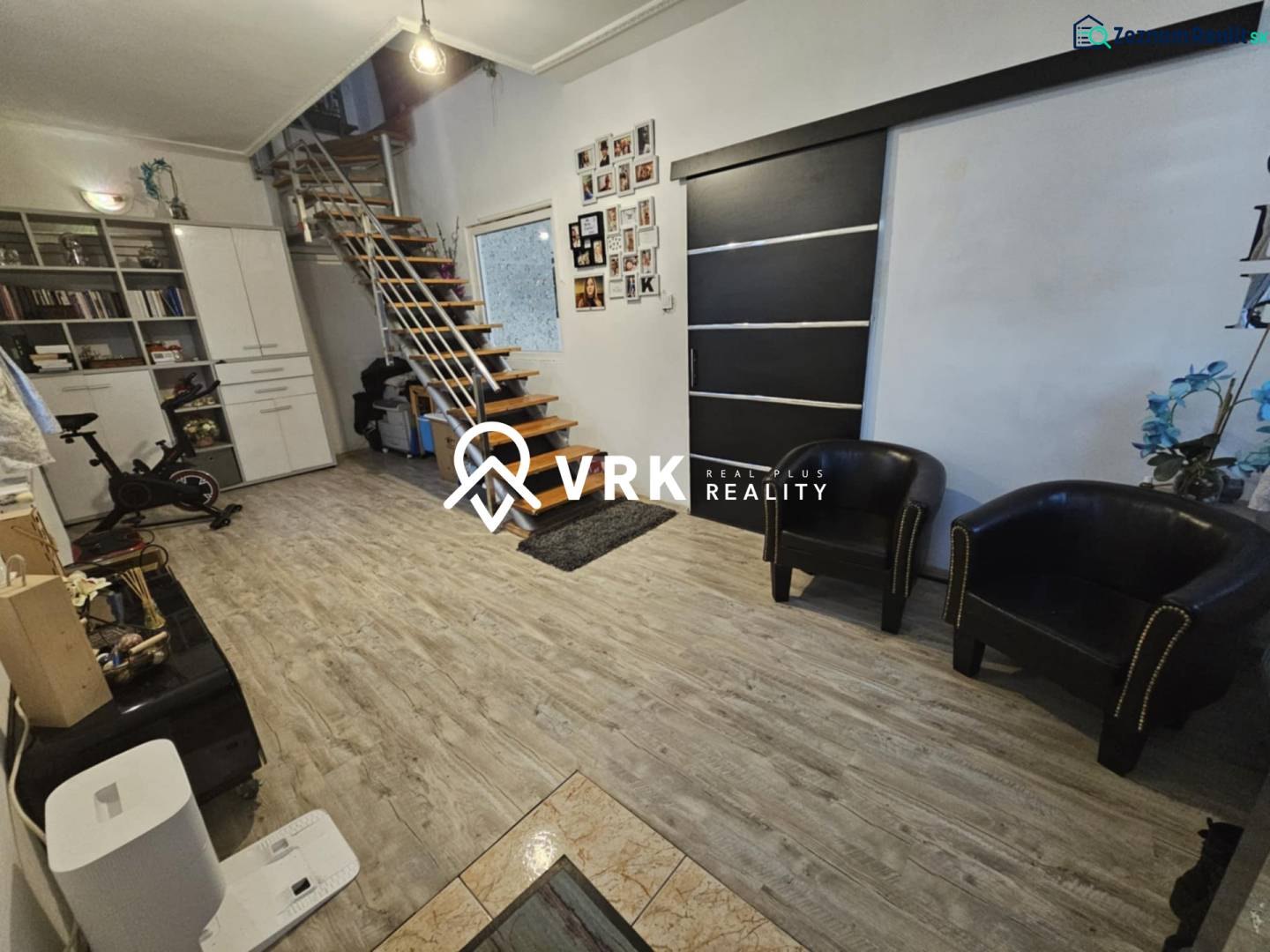 Innenraum eines Einfamilienhauses mit modernen Treppen und einem Boden in Holzoptik.