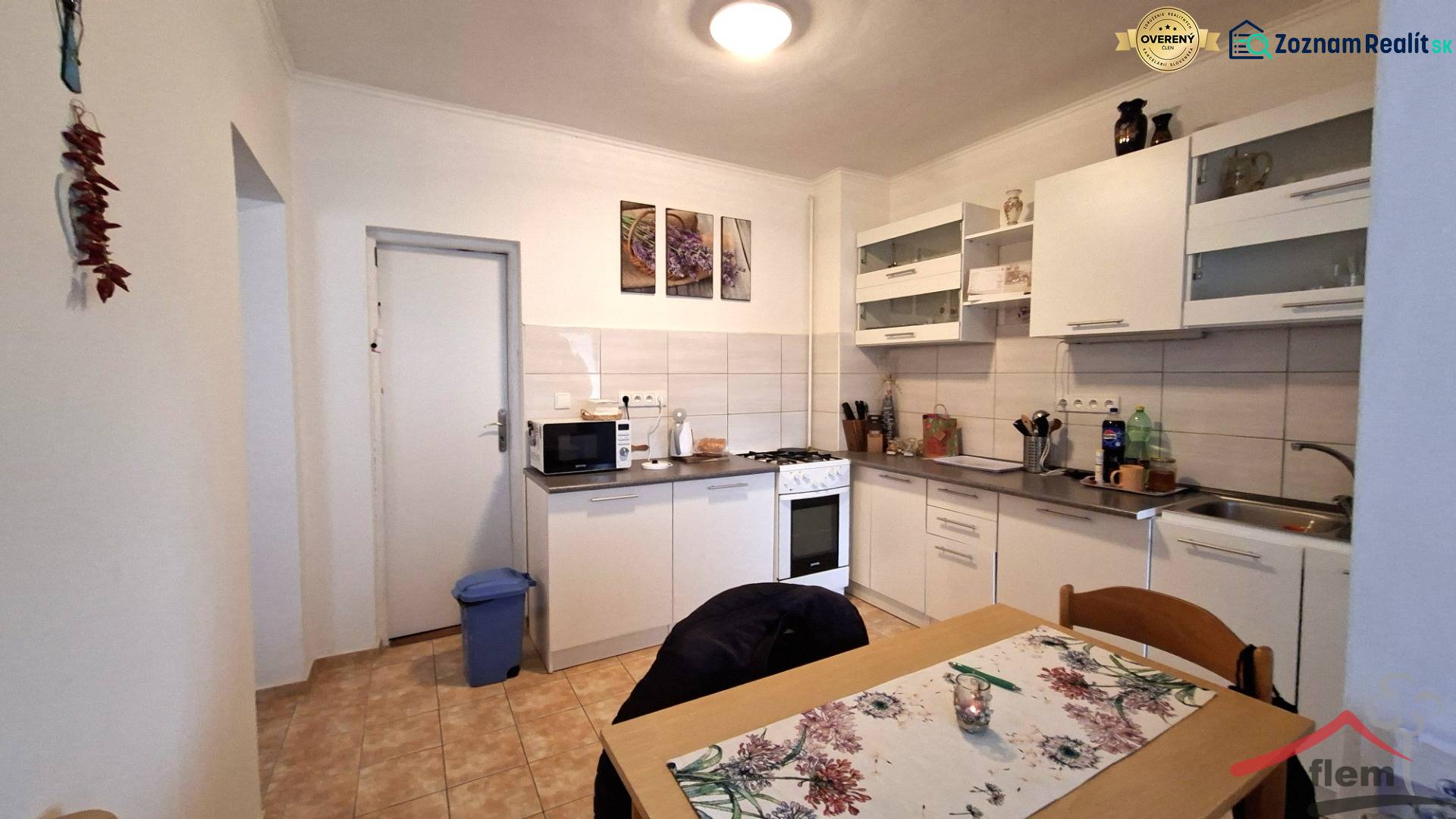 Küche in einem Einfamilienhaus mit weißen Möbeln, Herd und Esstisch.