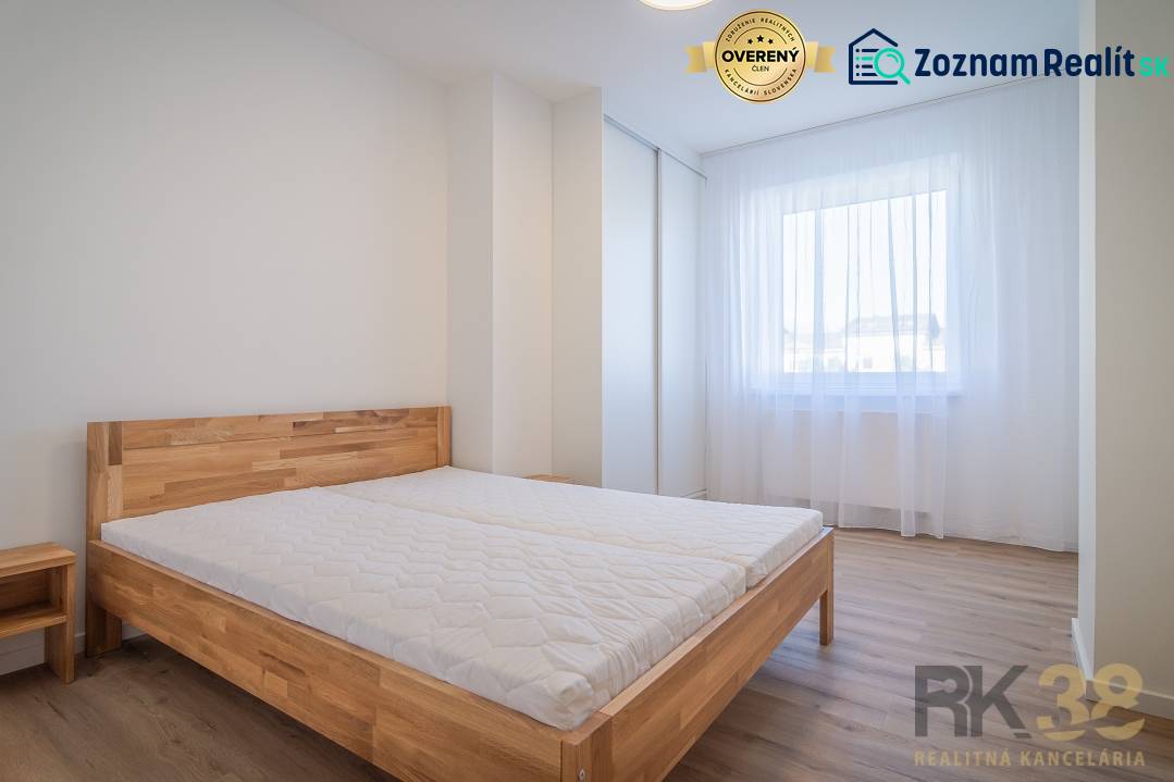 Helles Schlafzimmer mit Holzbett und Fenster in einer 2-Zimmer-Wohnung.