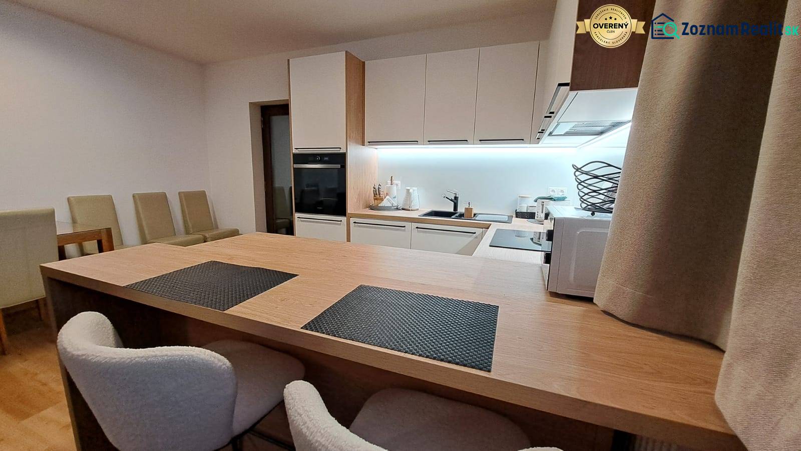 Küche in einer 2-Zimmer-Wohnung mit eingebauten Geräten und einem Boden in Holzoptik.