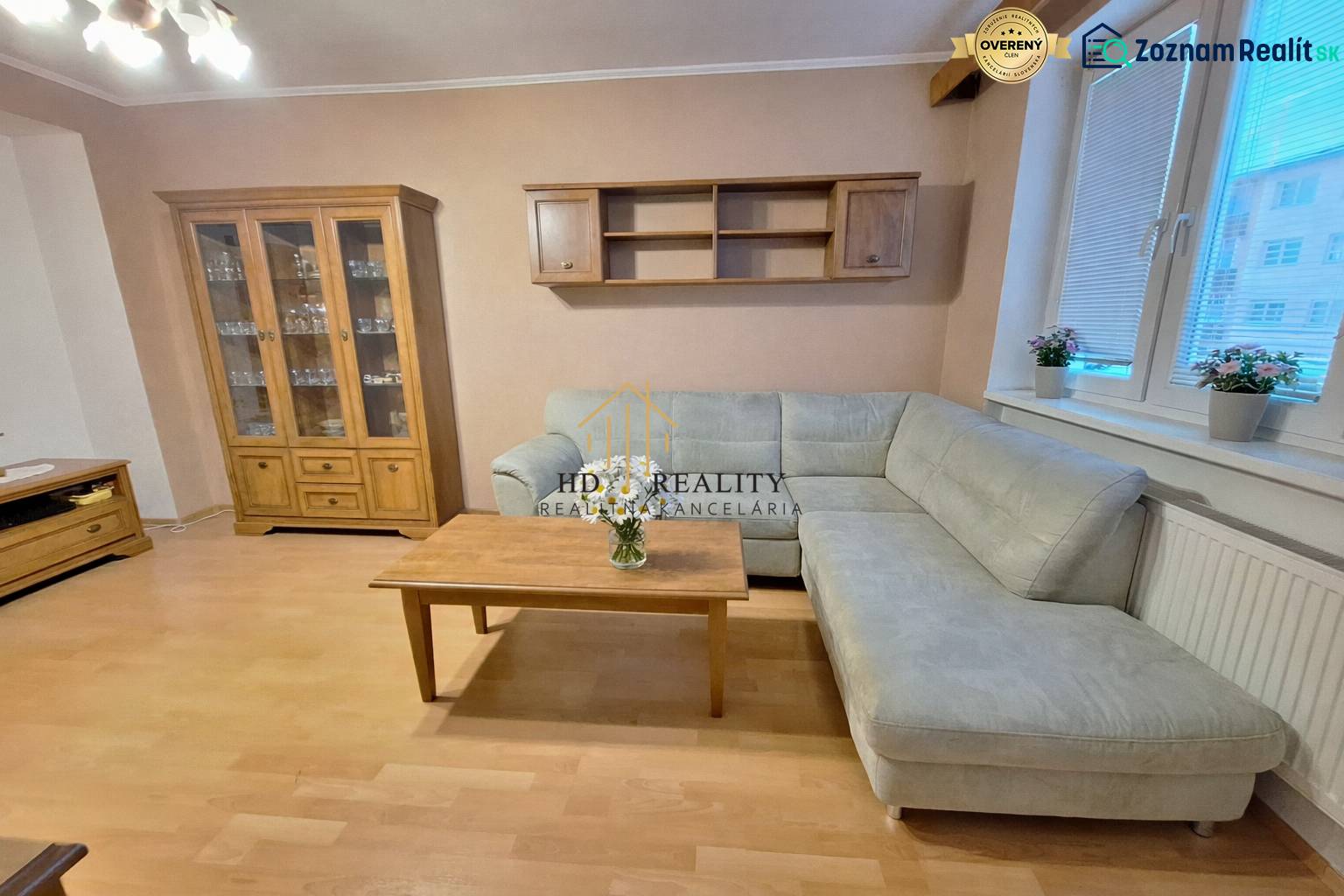 Wohnzimmer in einer 2-Zimmer-Wohnung mit Ecksofa, Holzelemente ergänzen das Interieur.