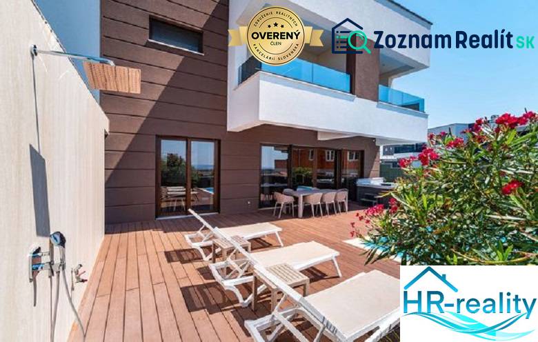 Terrasse mit Liegestühlen bei der Villa in Novalja mit Meerblick und Dusche.