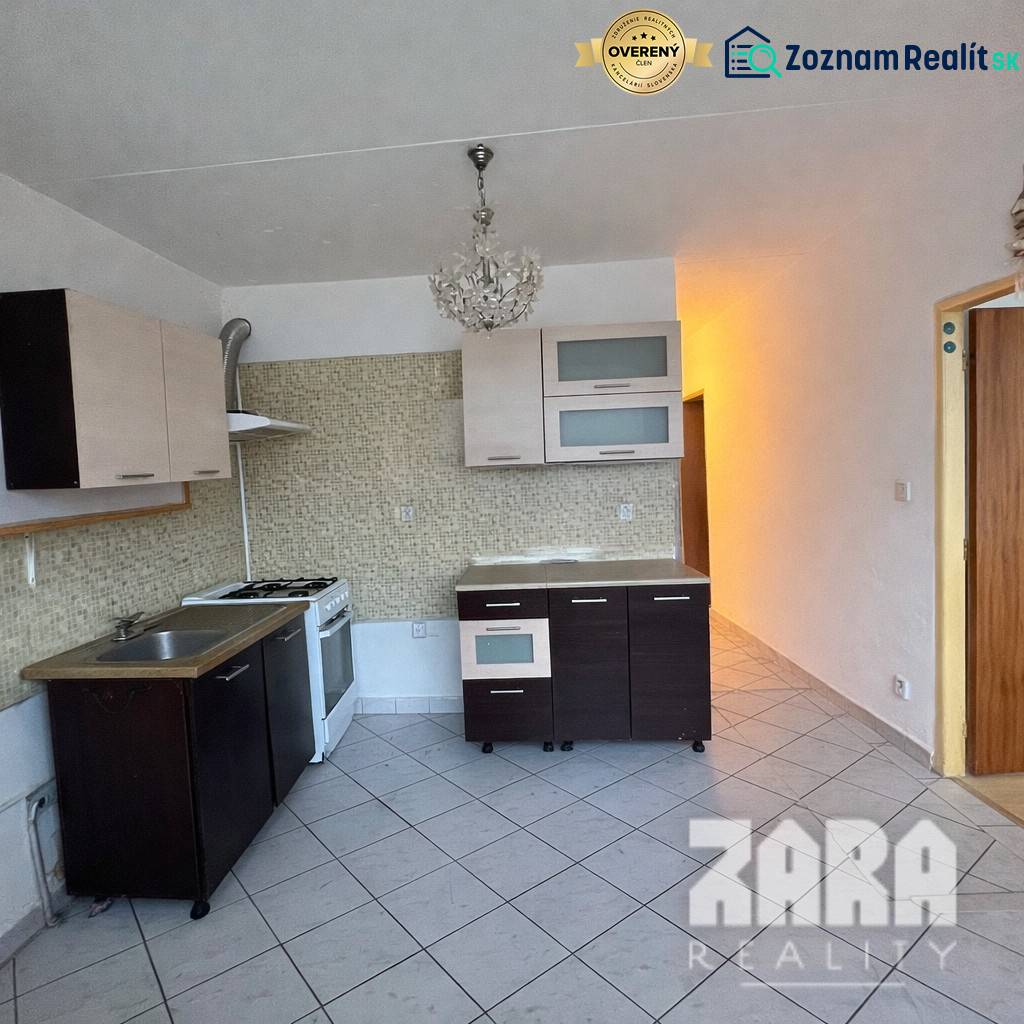 Küche in einer 3-Zimmer-Wohnung mit einem Gasherd und hellen Fliesen.