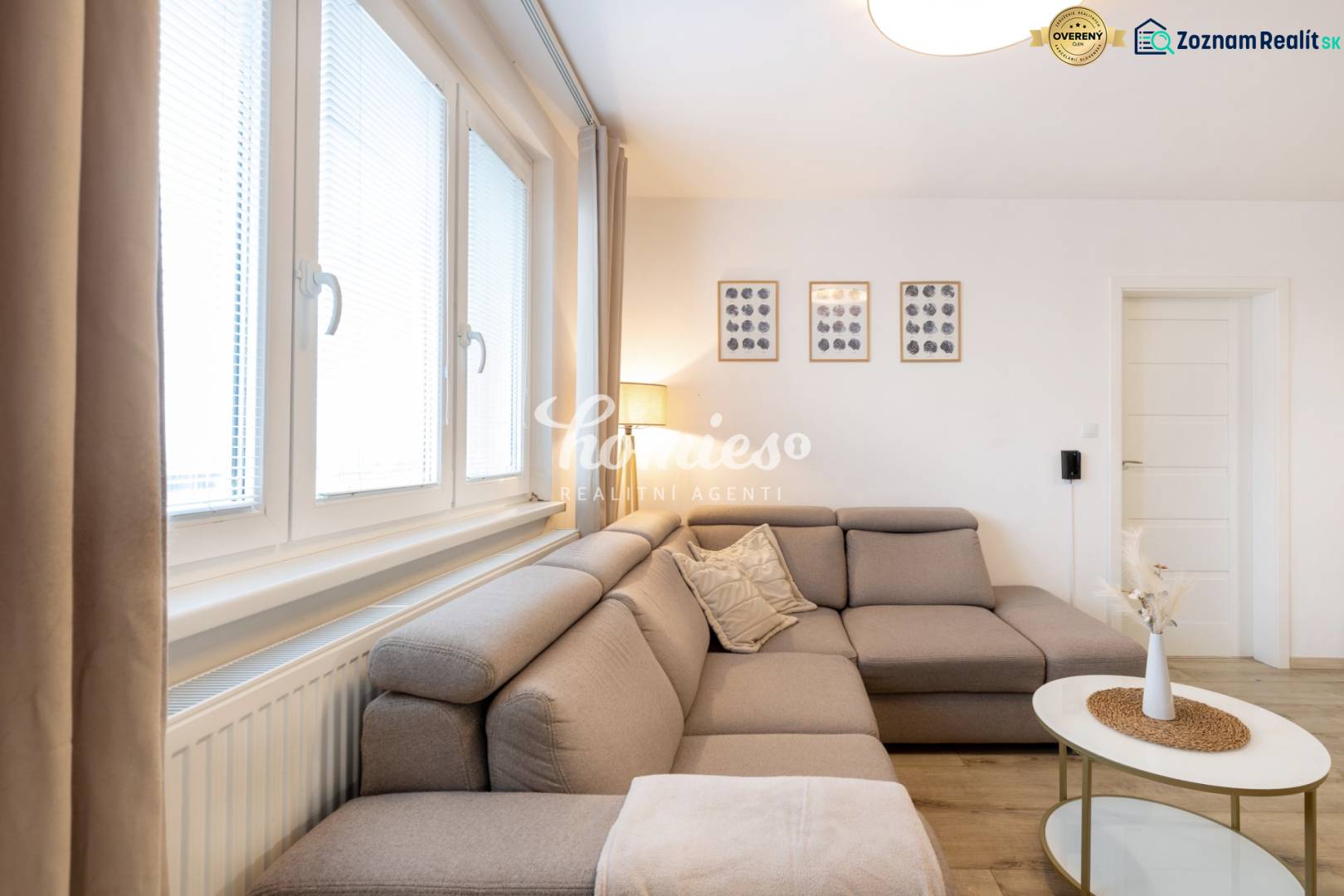 Wohnzimmer in einer Zweizimmerwohnung mit einem bequemen Sofa und Wanddekorationen.