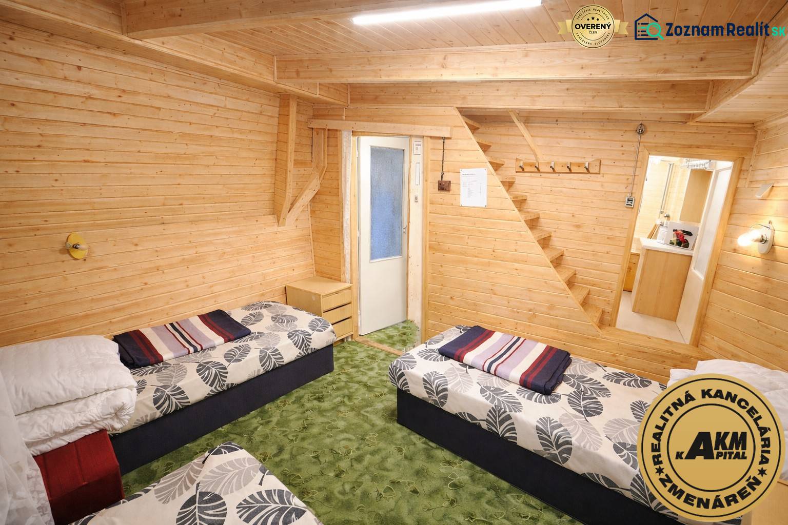 Das Innere der Hütte besteht aus zwei Betten, Holzverkleidungen und einem grünen Teppich.