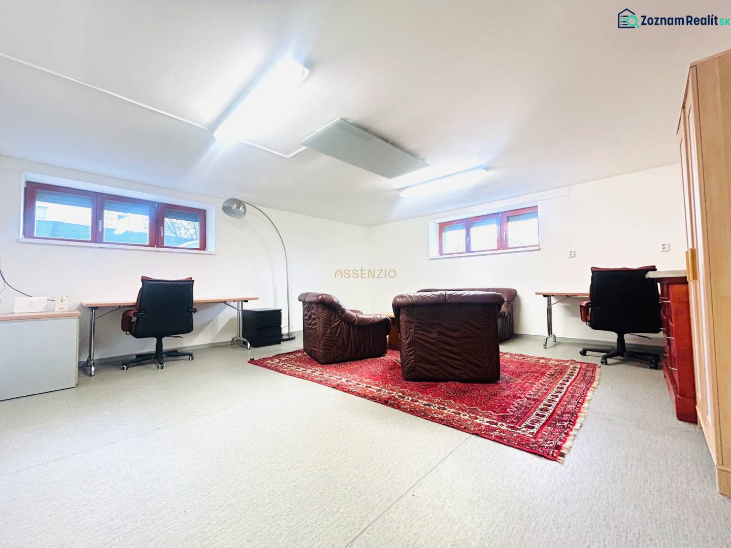 Heimbüro mit Teppichdekor und Ledersesseln in einem Einfamilienhaus.