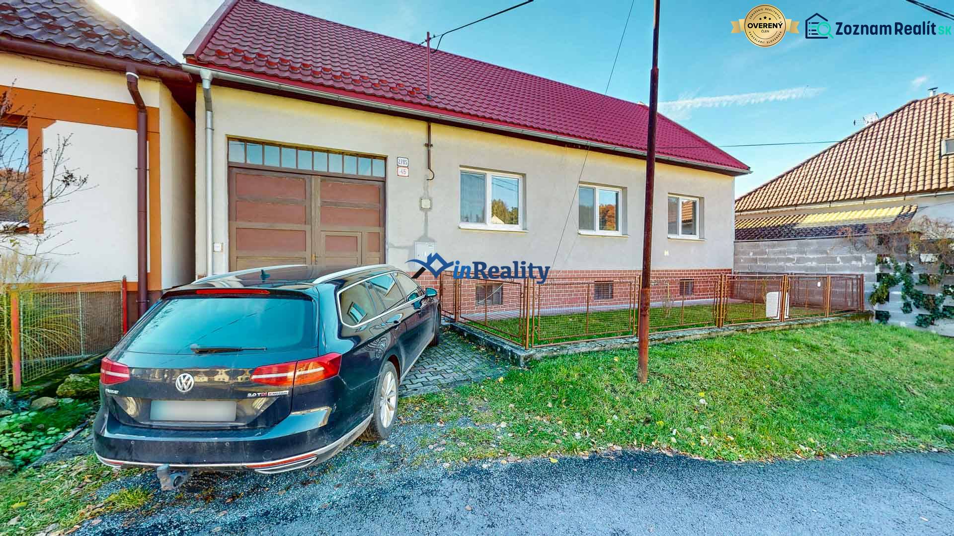 Ein Einfamilienhaus in Lieskovec mit einer geräumigen Garage und einem Auto auf einer befestigten Fläche.