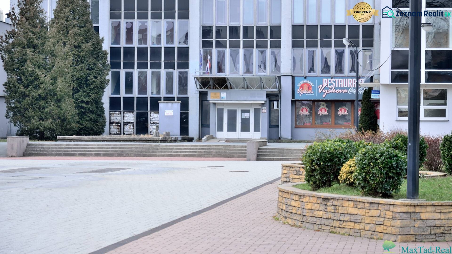 Ein Bürogebäude am Freiheitsplatz in Michalovce, umgeben von Grünflächen und Gehwegen.