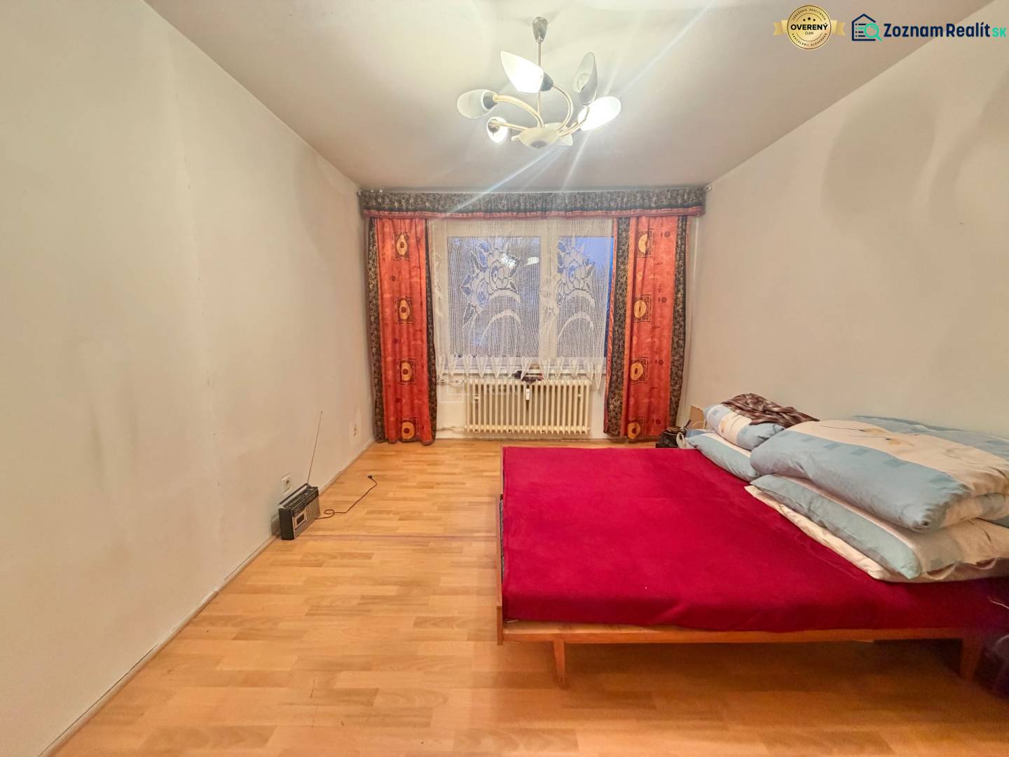 Schlafzimmer in einer 3-Zimmer-Wohnung mit Bett, Holzboden und Licht.