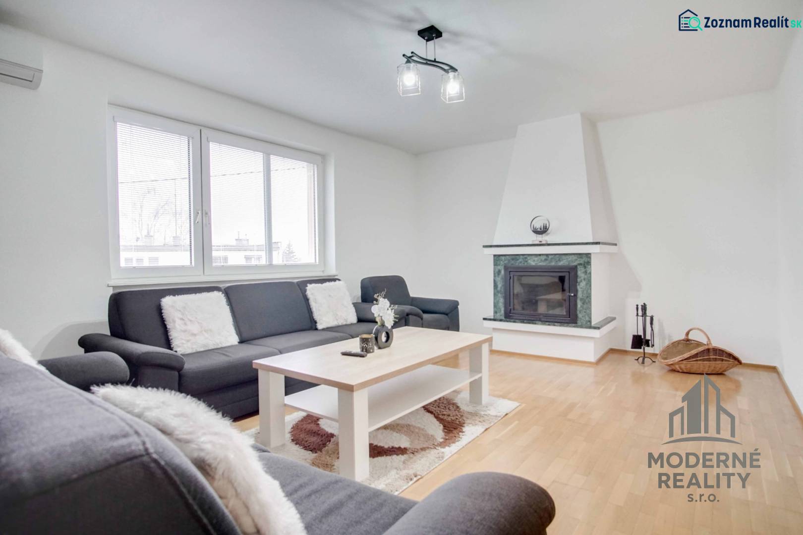 Wohnzimmer in einer 4-Zimmer-Wohnung mit Kamin und Boden in Holzoptik.