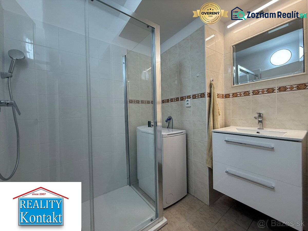 Badezimmer in einer 2-Zimmer-Wohnung mit Waschbecken, Dusche und Waschmaschine.