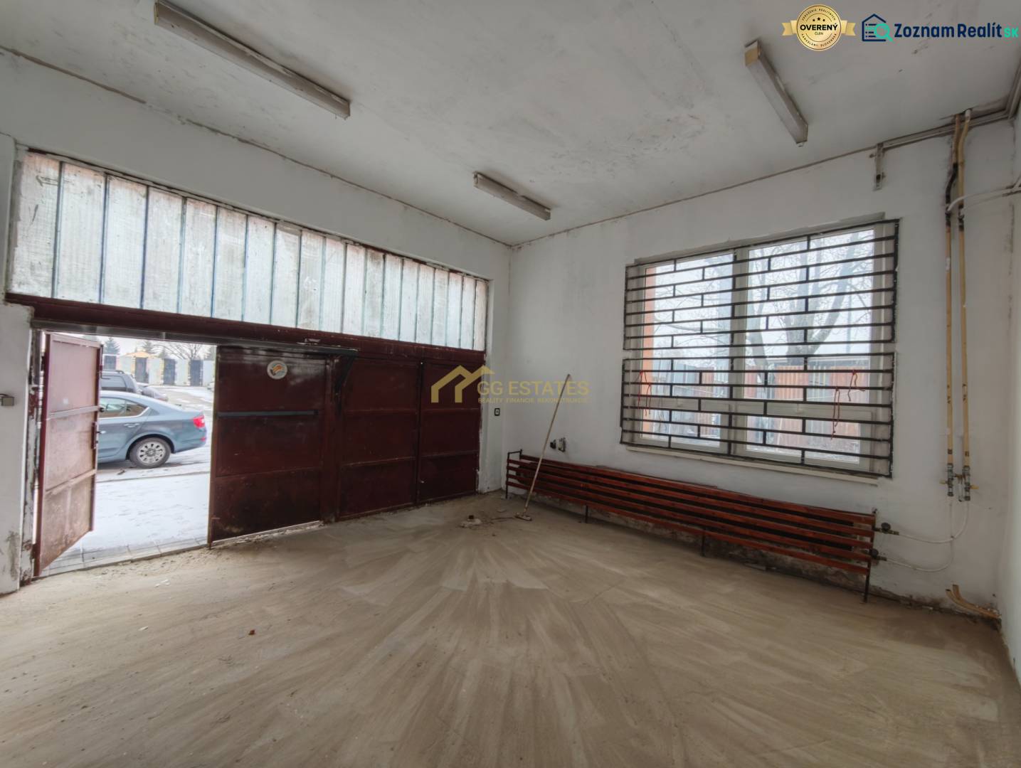 Innenraum einer Garage mit Holzdekorboden und Metalltor.