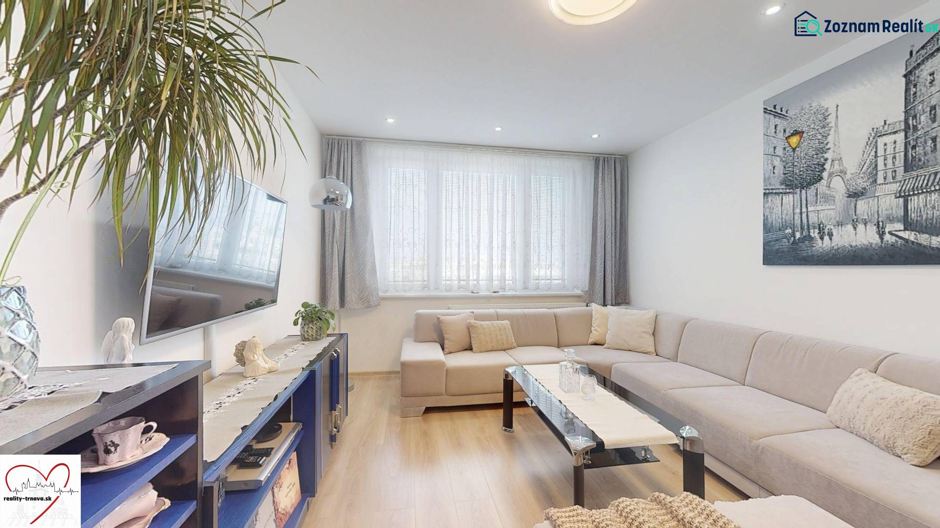 Wohnzimmer mit Holzboden, Sofa und Fernseher in einer 3-Zimmer-Wohnung.