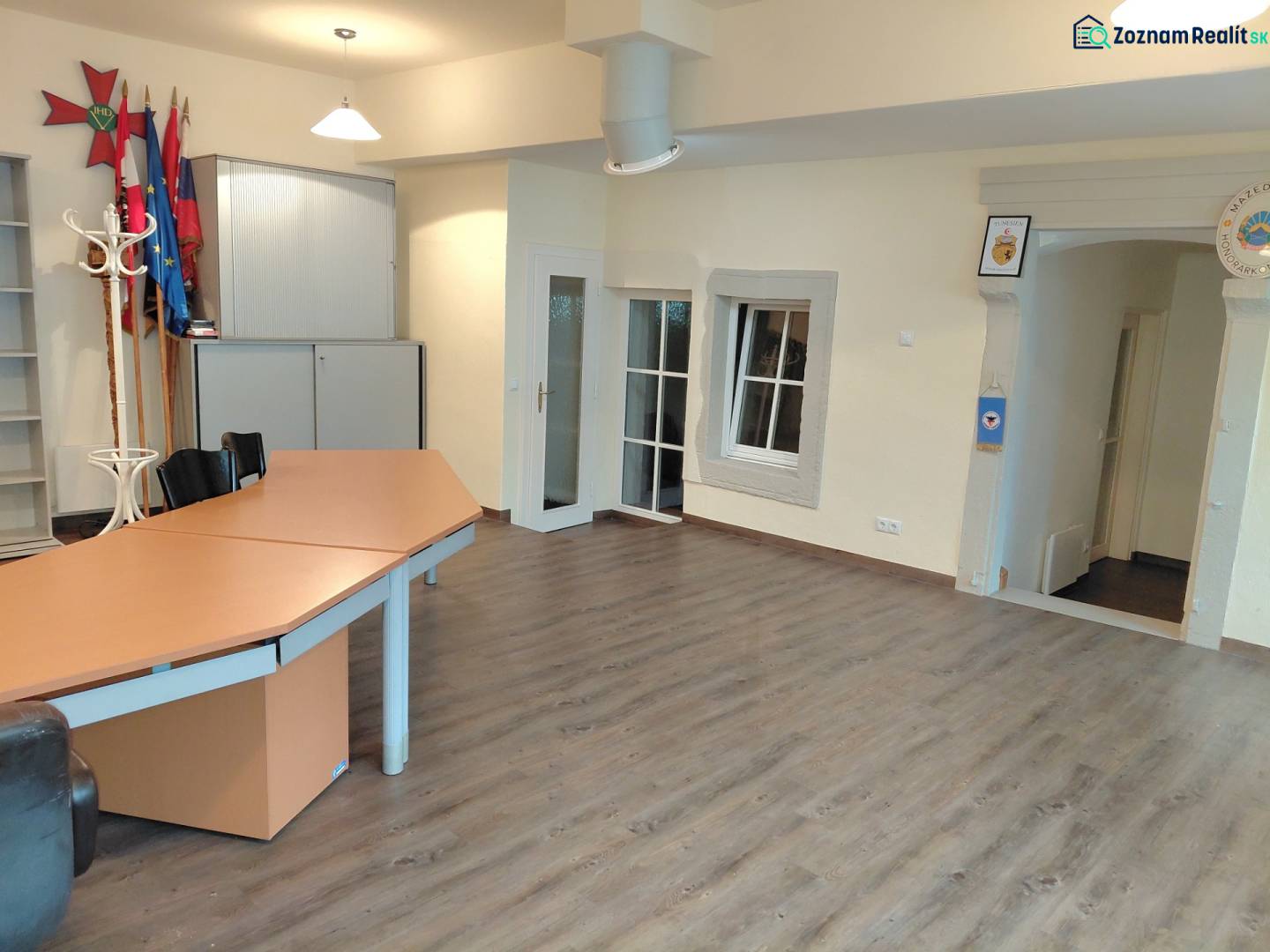 Büros mit Holzboden, Tisch und Schränken.