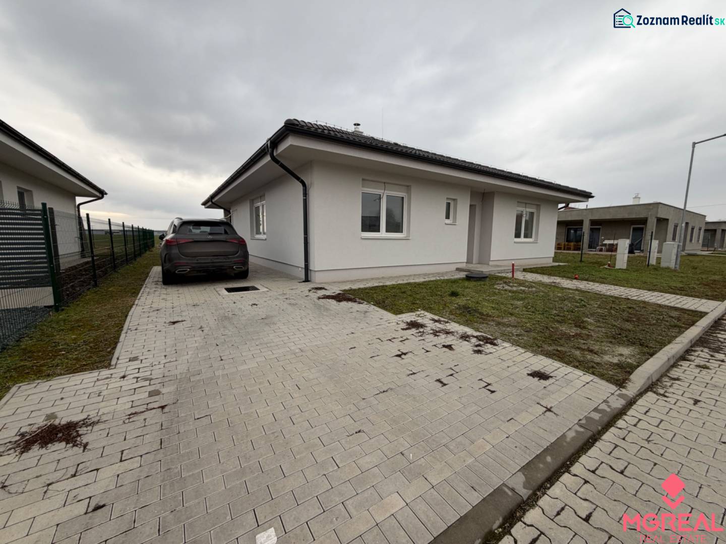 Ein Einfamilienhaus in der Tichastraße in Práznovce mit einem Auto auf der gepflasterten Auffahrt.