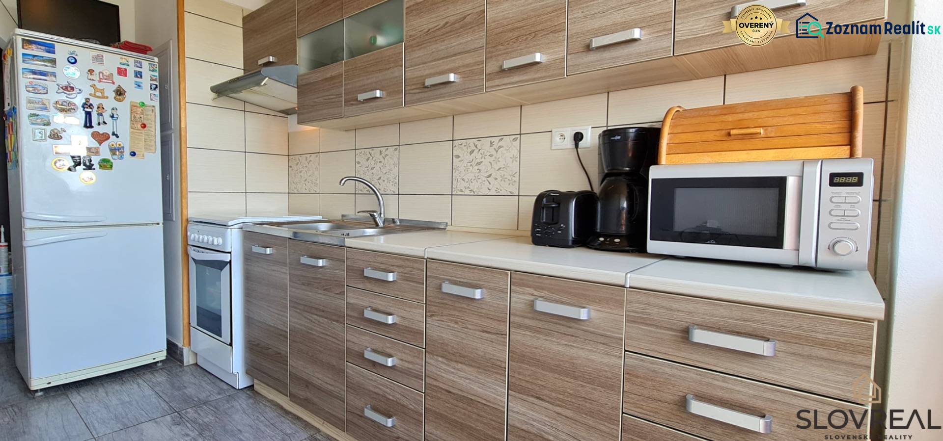 Küche in einer 2-Zimmer-Wohnung mit Holzboden und Geräten.