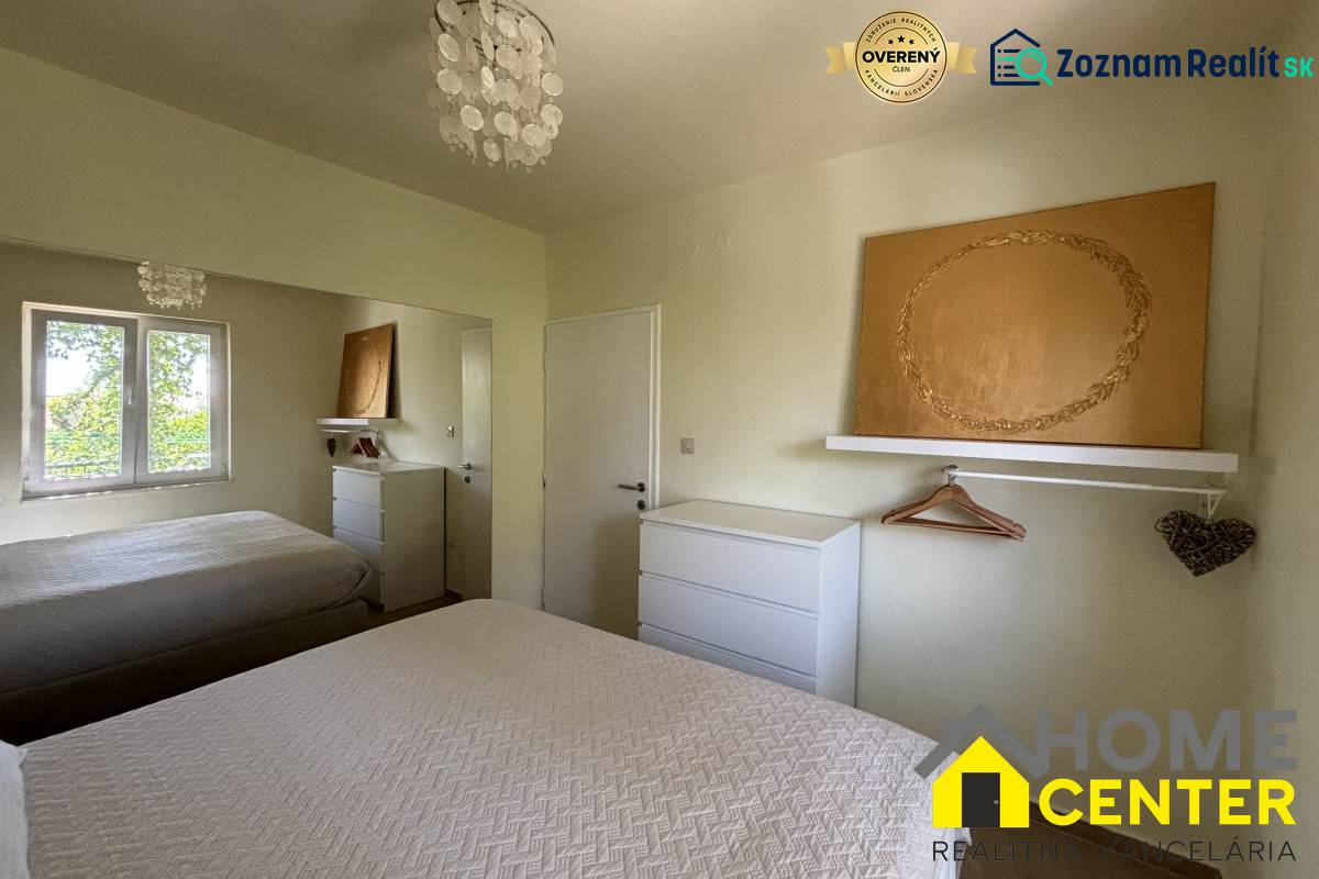 Schlafzimmer in einem Einfamilienhaus mit weißen Möbeln, Spiegel und texturierten Bettüberwürfen.