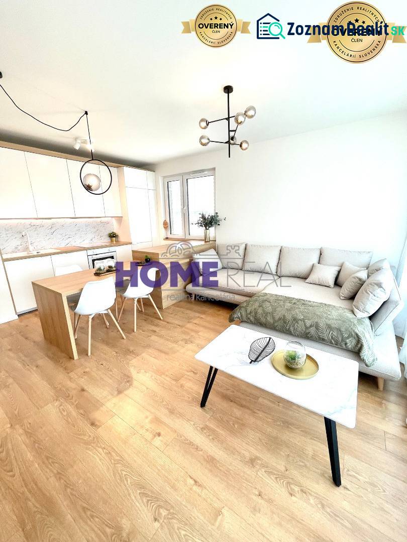 Wohnzimmer mit Küche in einer 3-Zimmer-Wohnung, helle Couch, Boden mit Holzdekor.