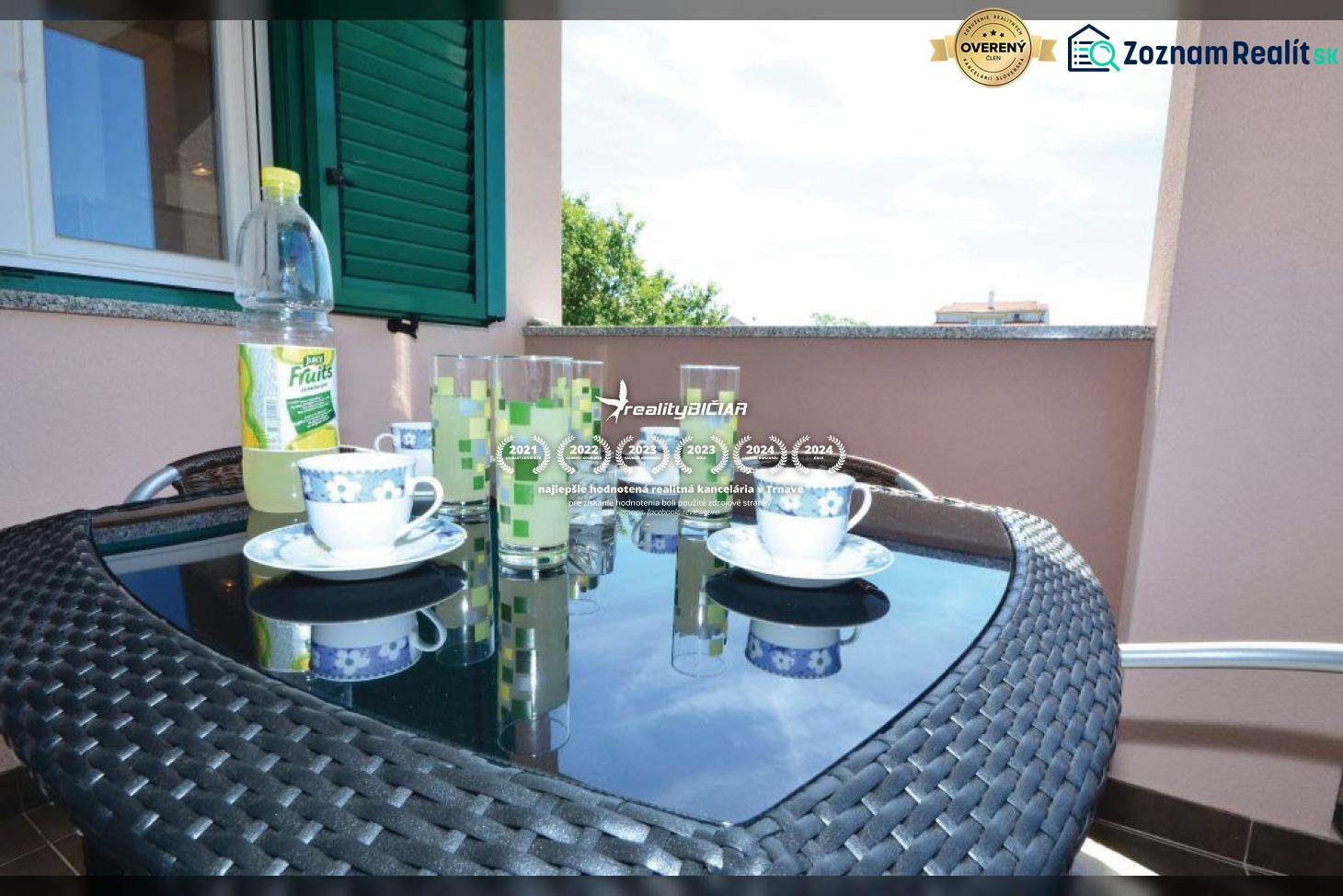 Der Balkon einer 2-Zimmer-Wohnung mit einem Korbtisch, Teeservice und Blick auf Privlaka.