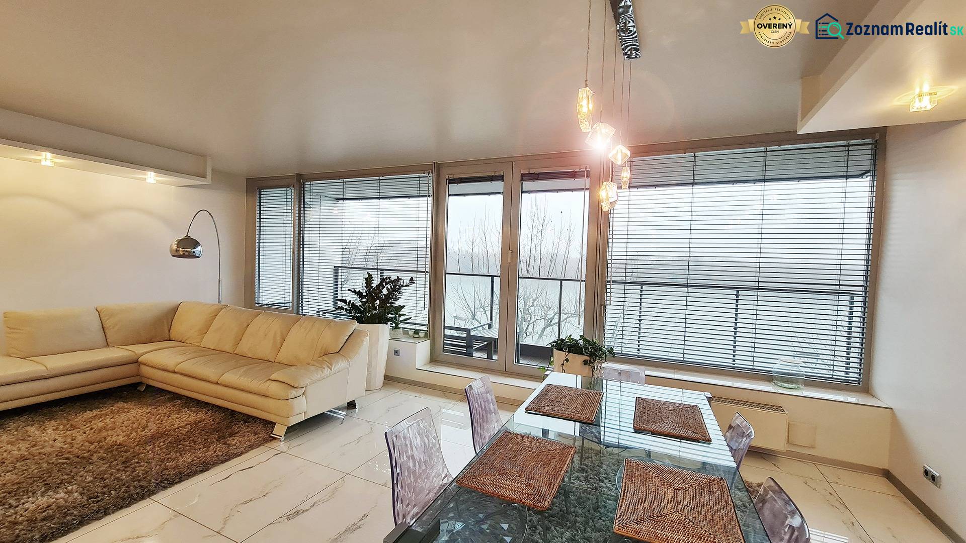 Wohnzimmer in einer 3-Zimmer-Wohnung mit heller Couch, Tisch und Glastüren.