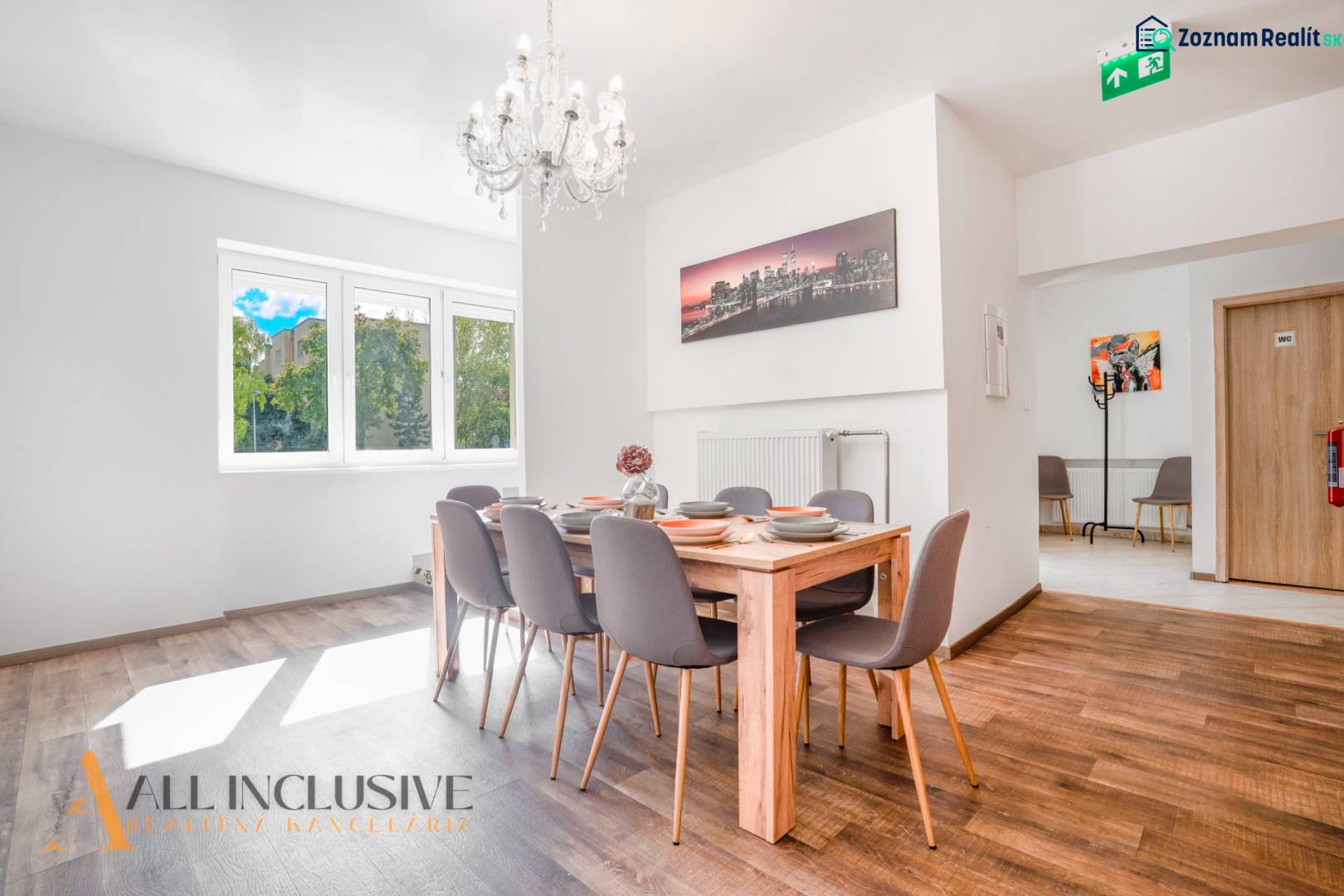 Ein Speisesaal mit einem Kronleuchter und einem Holzboden in einem Gebäude.