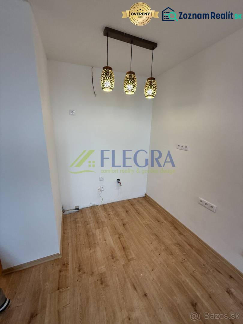 Innenraum einer Einzimmerwohnung mit Holzboden und Hängelampen.