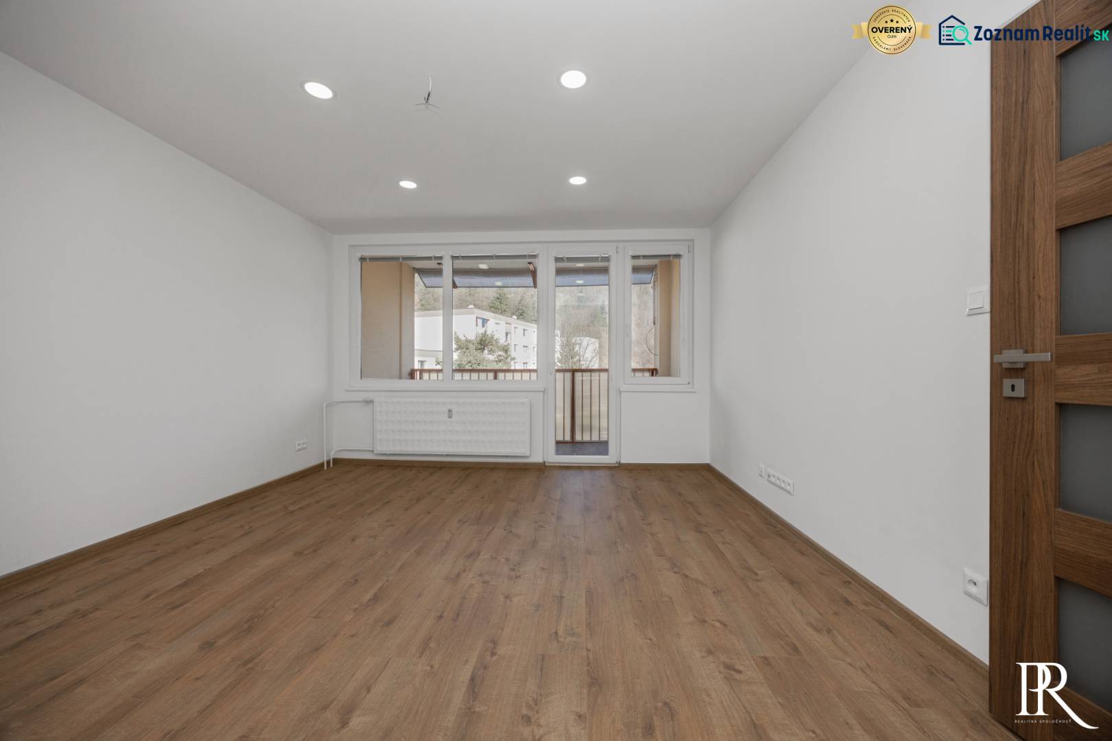 Helles Zimmer in einer 3-Zimmer-Wohnung mit Holzboden und Balkontüren.