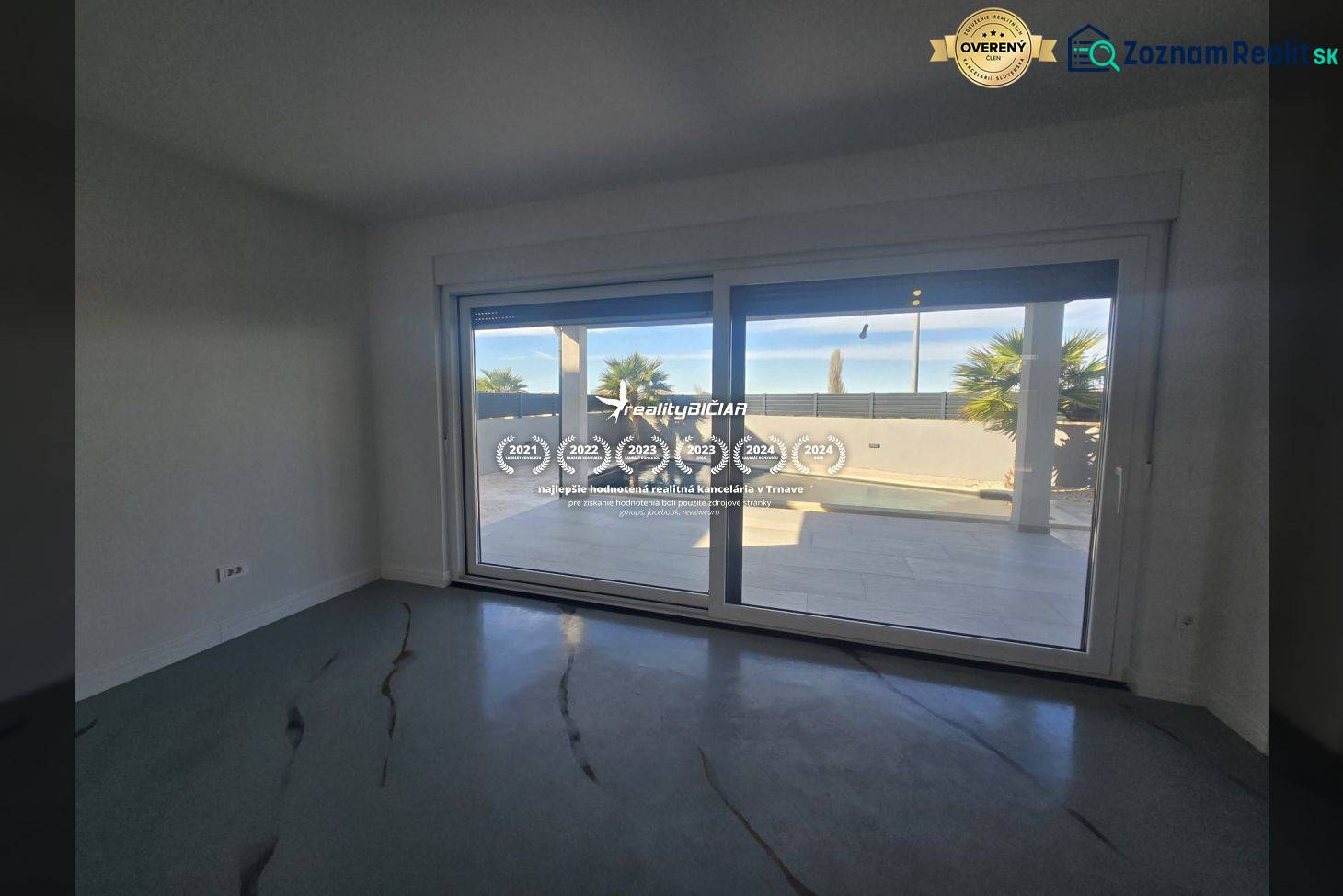 Innenraum der Villa mit großen Verglasungen und Blick auf den Außenbereich mit Pool.