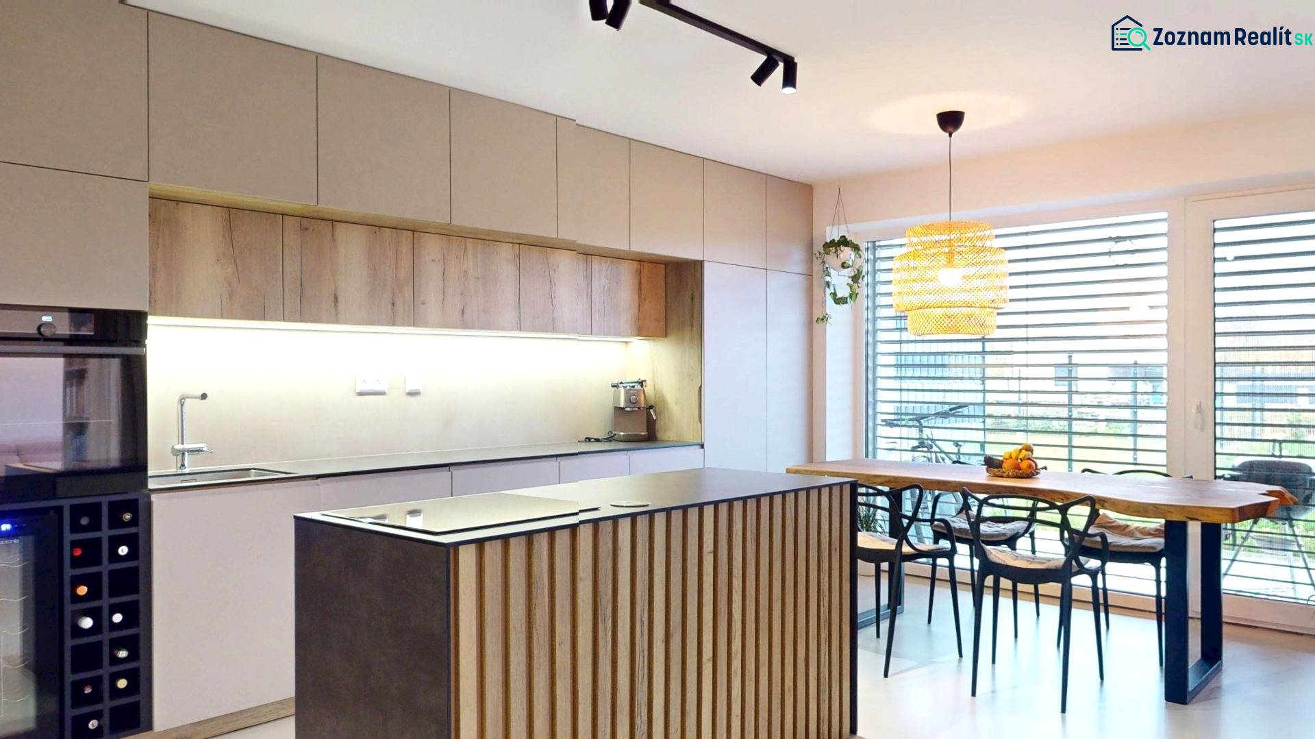 Küche in einem Einfamilienhaus mit Holzmöbeldekor und großen Fenstern.