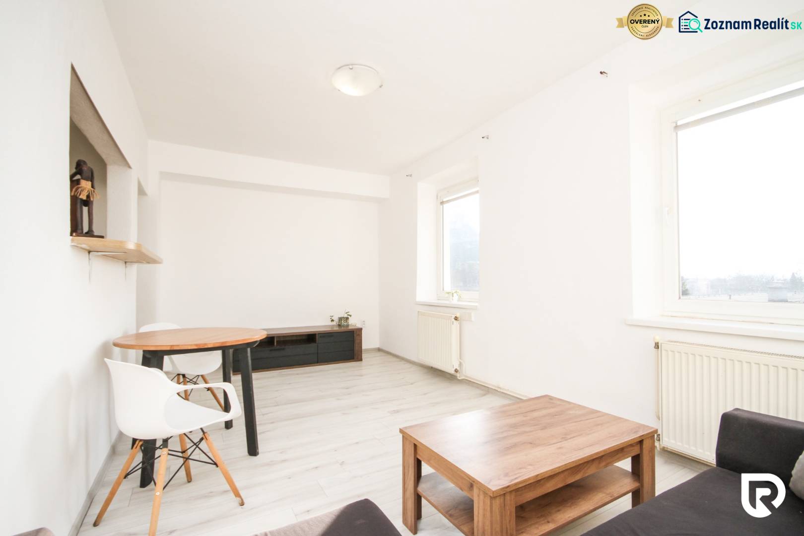 Helles Wohnzimmer in einer 2-Zimmer-Wohnung mit Holzboden und einfacher Einrichtung.