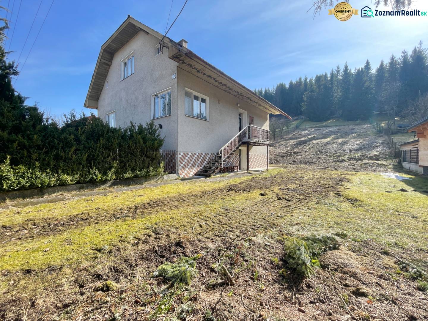 Ein Einfamilienhaus in Terchová mit einem großen Rasenstück, umgeben von Bäumen.