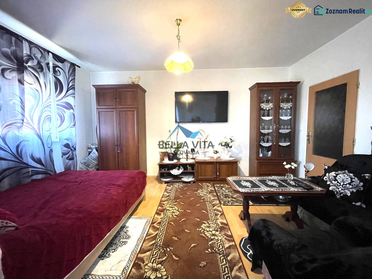 Wohnzimmer in einer Einzimmerwohnung mit Holzboden und Möbeln.