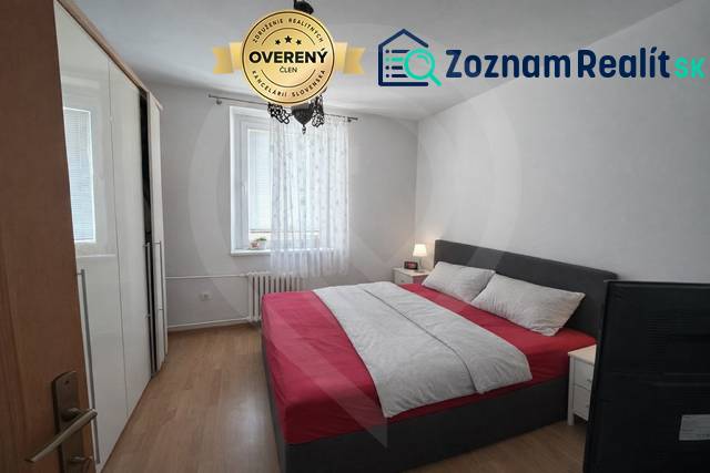 Schlafzimmer mit Bett und Schrank, Boden mit Holzdekor, 3-Zimmer-Wohnung.