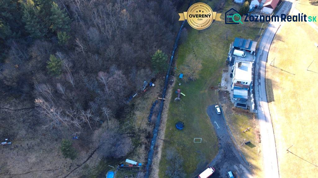 Luftaufnahme von Erholungsgrundstücken in Župkova mit Gebäuden, Bäumen und einer Straße.