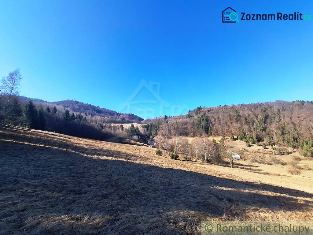 Weitläufige landwirtschaftliche und forstwirtschaftliche Flächen in der Umgebung von Hronec, umgeben von Wäldern und Hügeln.