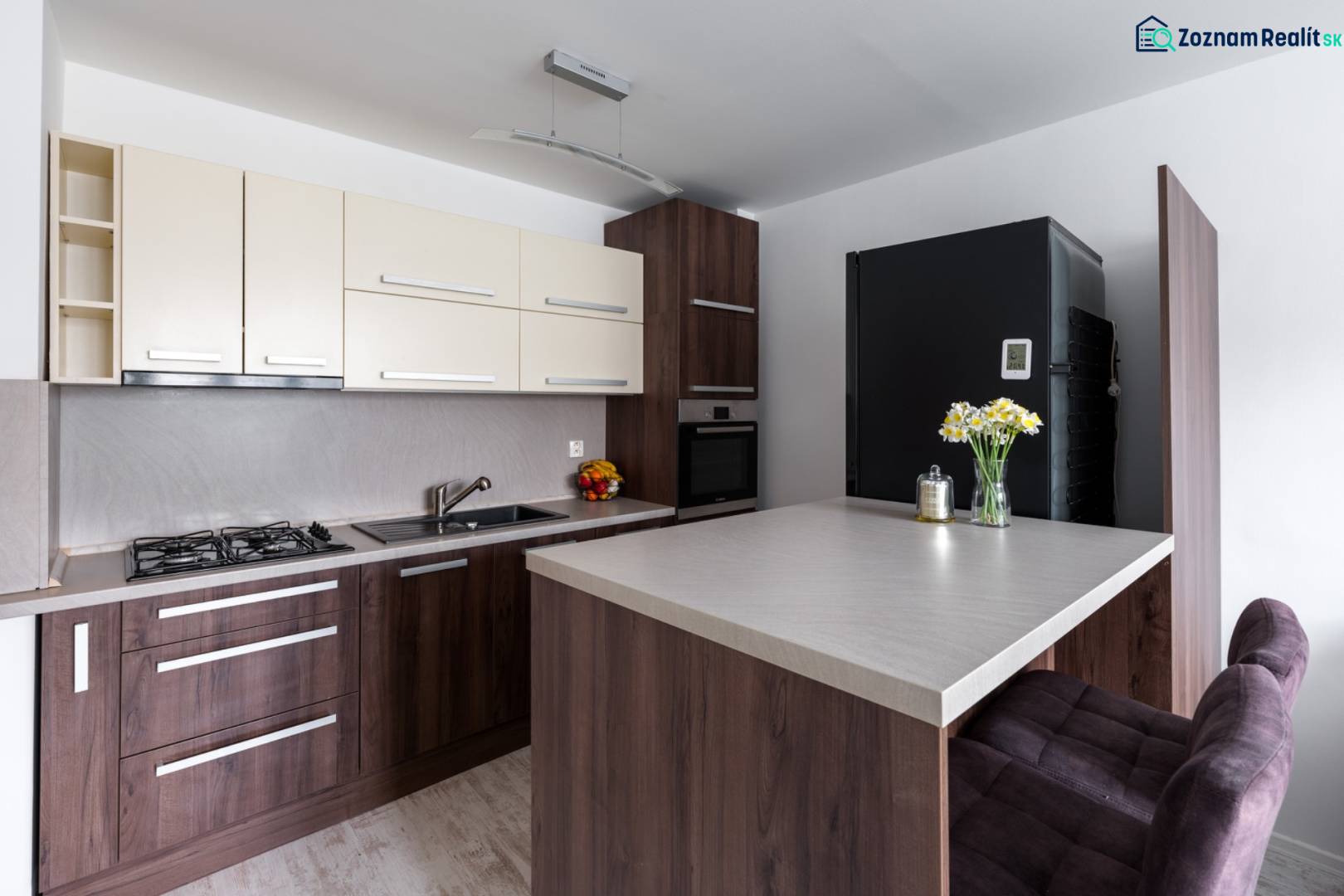 Küche in einer 2-Zimmer-Wohnung mit Holzboden, Bartresen und moderner Ausstattung.