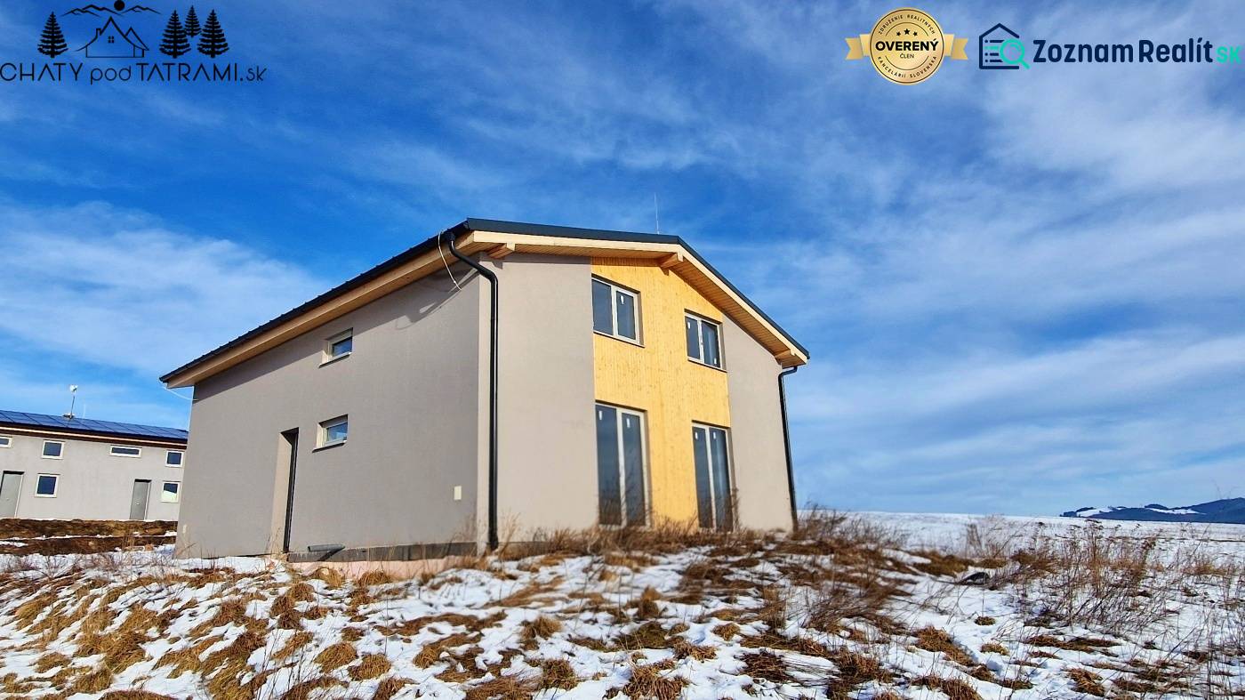 Eine Hütte in Dolná Lehota mit Holzeinrichtung, verschneitem Grundstück und bewölktem Himmel.