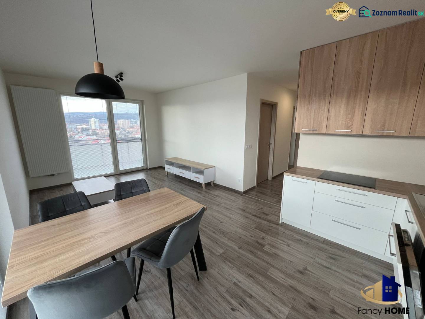 Essbereich mit Holzboden in einer 3-Zimmer-Wohnung, Küchenzeile und Ausblick.