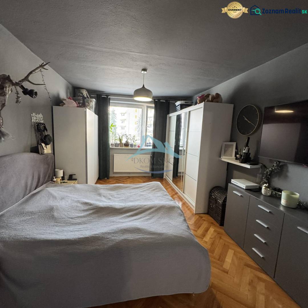 Schlafzimmer in einer 3-Zimmer-Wohnung mit Schrank, Bett und Boden in Holzoptik.