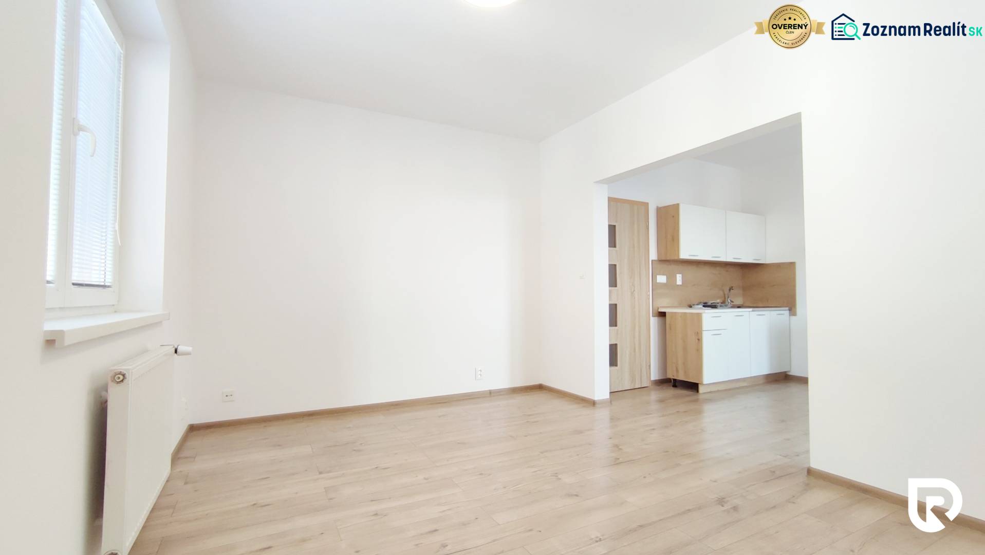 Innenraum einer 2-Zimmer-Wohnung mit Küche und Boden in Holzoptik.