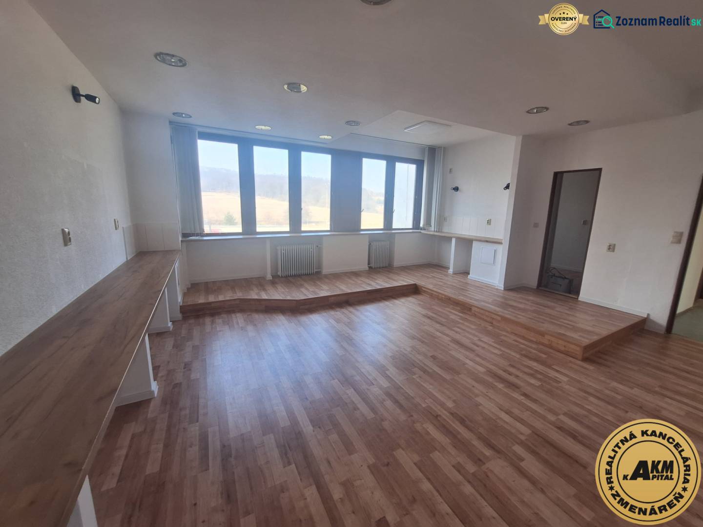 Geschäftsräume mit Holzboden und großen Fenstern.