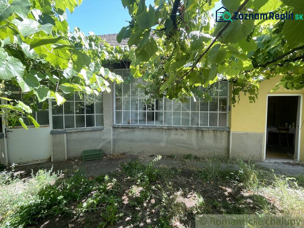 Ein Einfamilienhaus in Tvrdošovce mit einer von Grün umgebenen Veranda, ein Garten mit Weinreben.