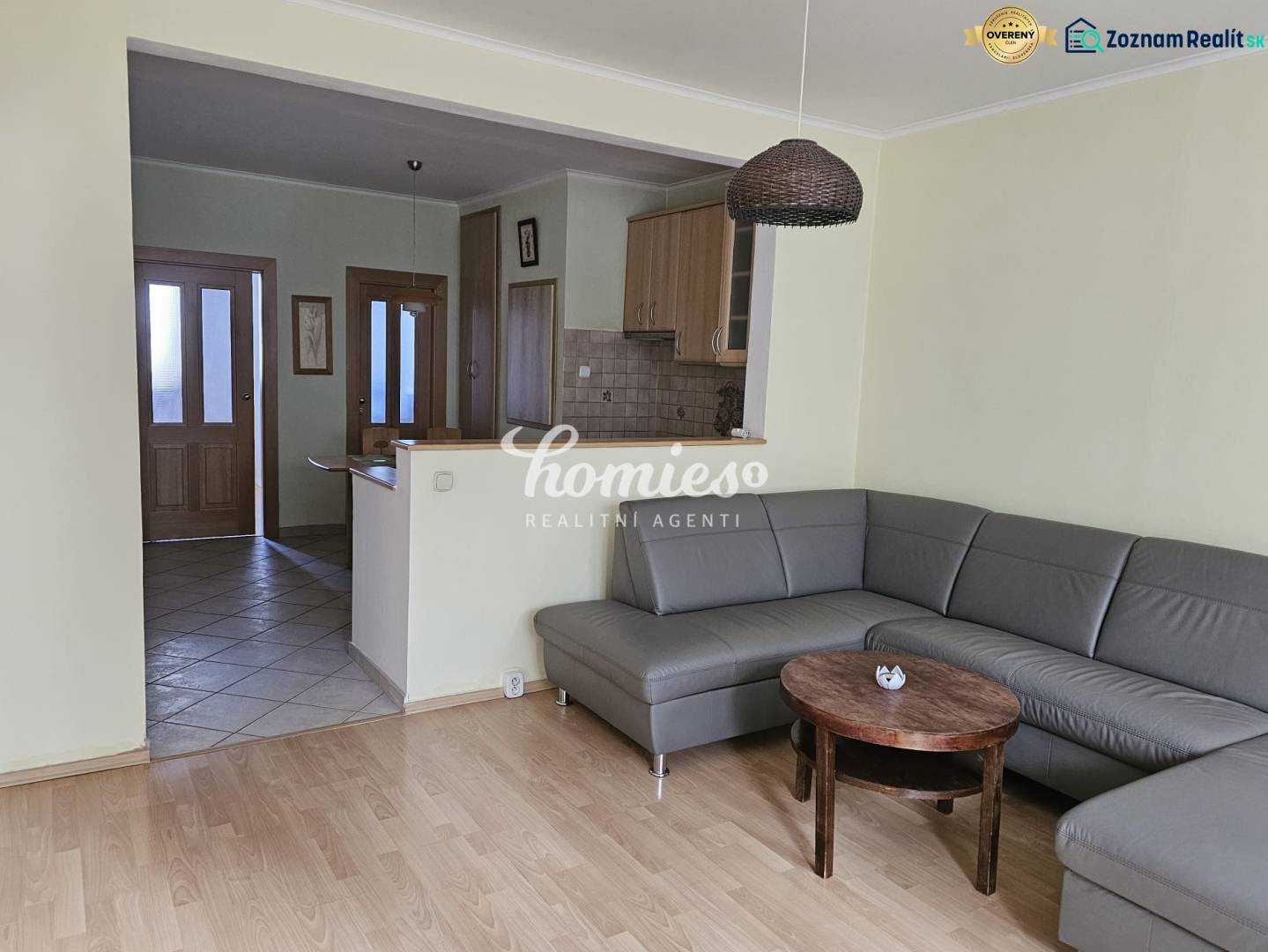 Wohnzimmer mit Ecksofa und Holzboden in einer 3-Zimmer-Wohnung.