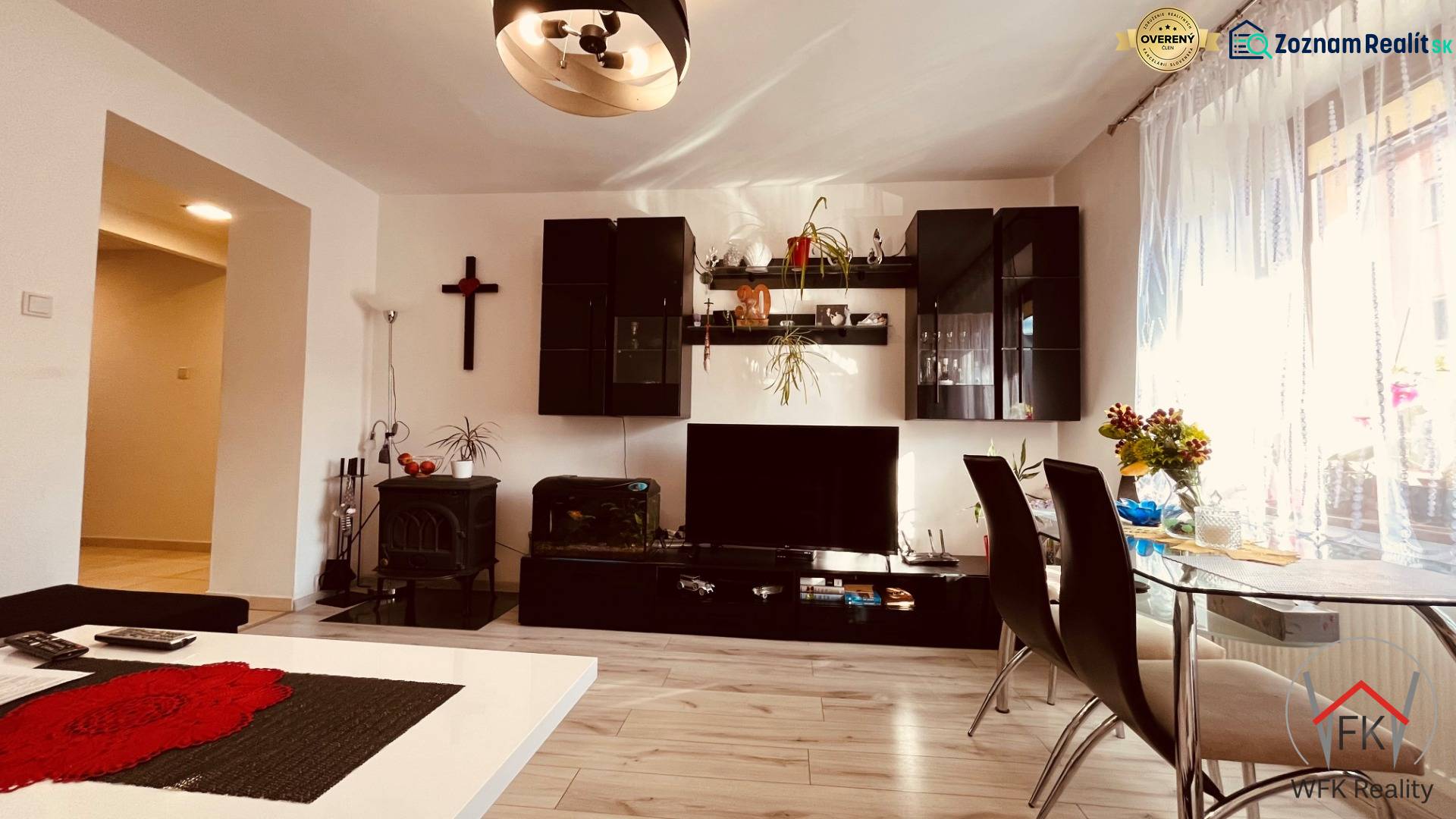 Wohnzimmer einer 3-Zimmer-Wohnung mit Holzboden, Esstisch und Wandregal.