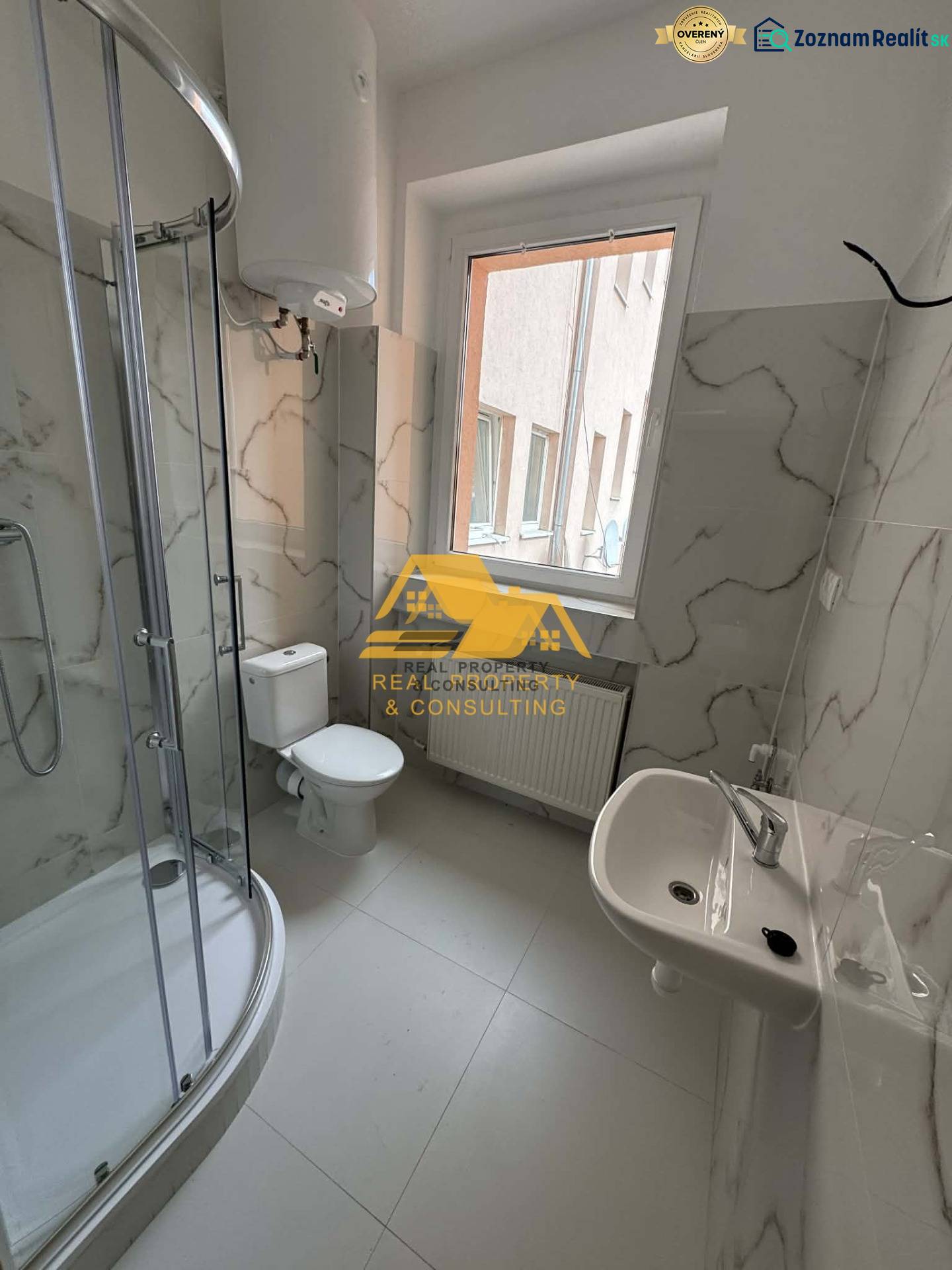 Badezimmer in einer Einzimmerwohnung mit einer Eckdusche und Keramikfliesen.