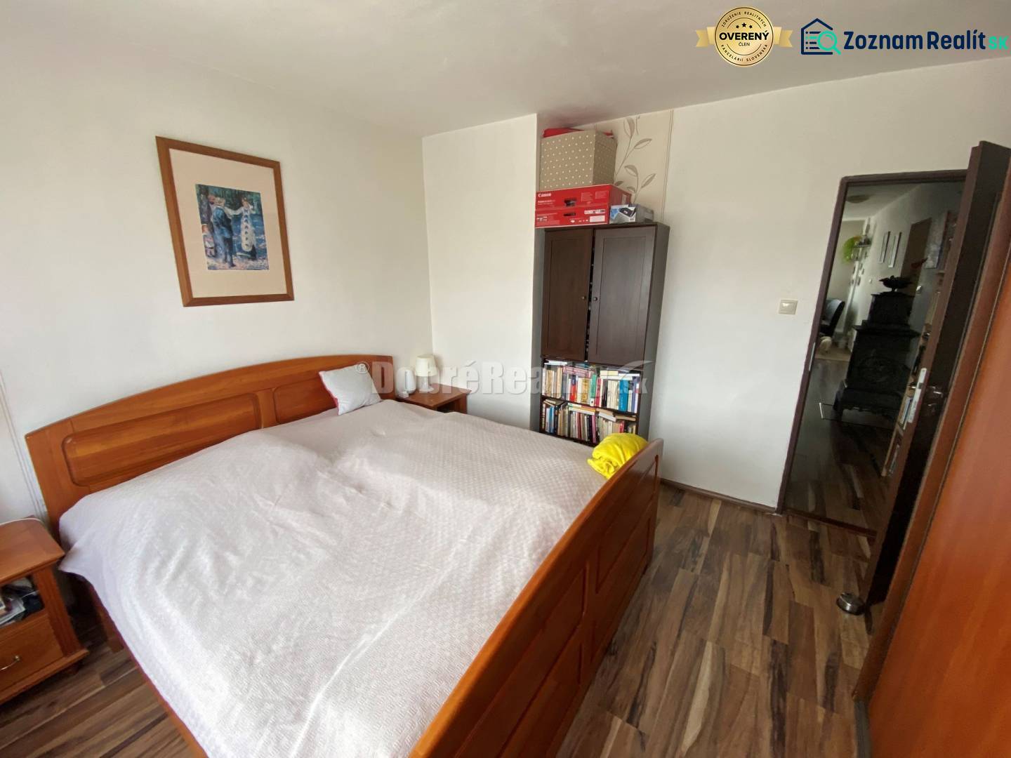 Schlafzimmer in einer 4-Zimmer-Wohnung mit Holzboden und Holzbett.