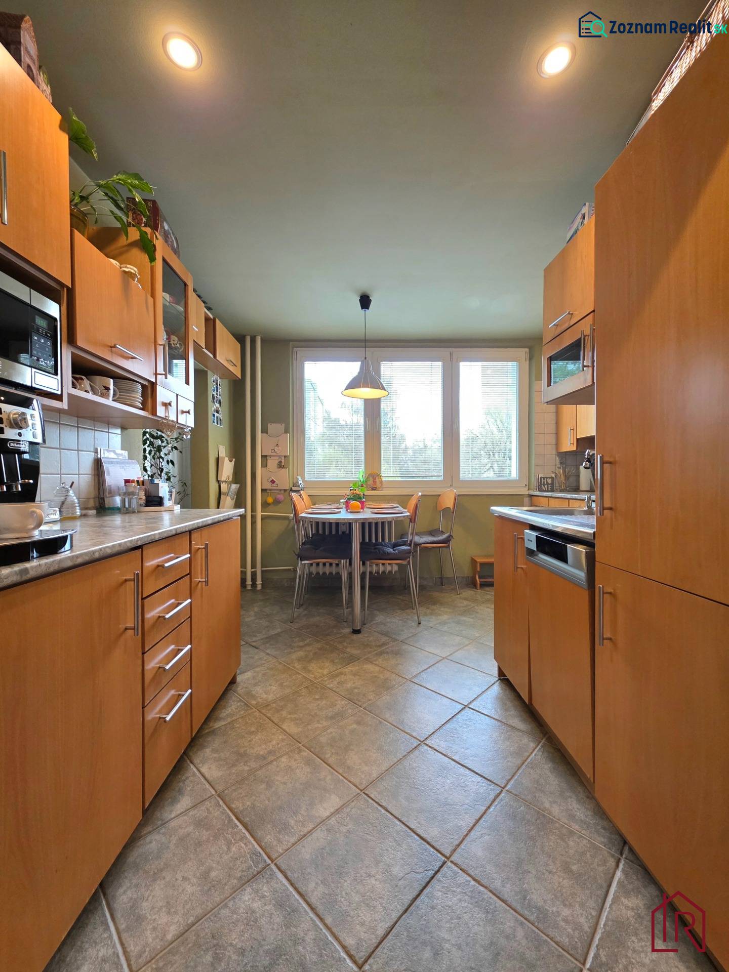 Küche in einer 4-Zimmer-Wohnung mit Esstisch und hellen Möbeln.