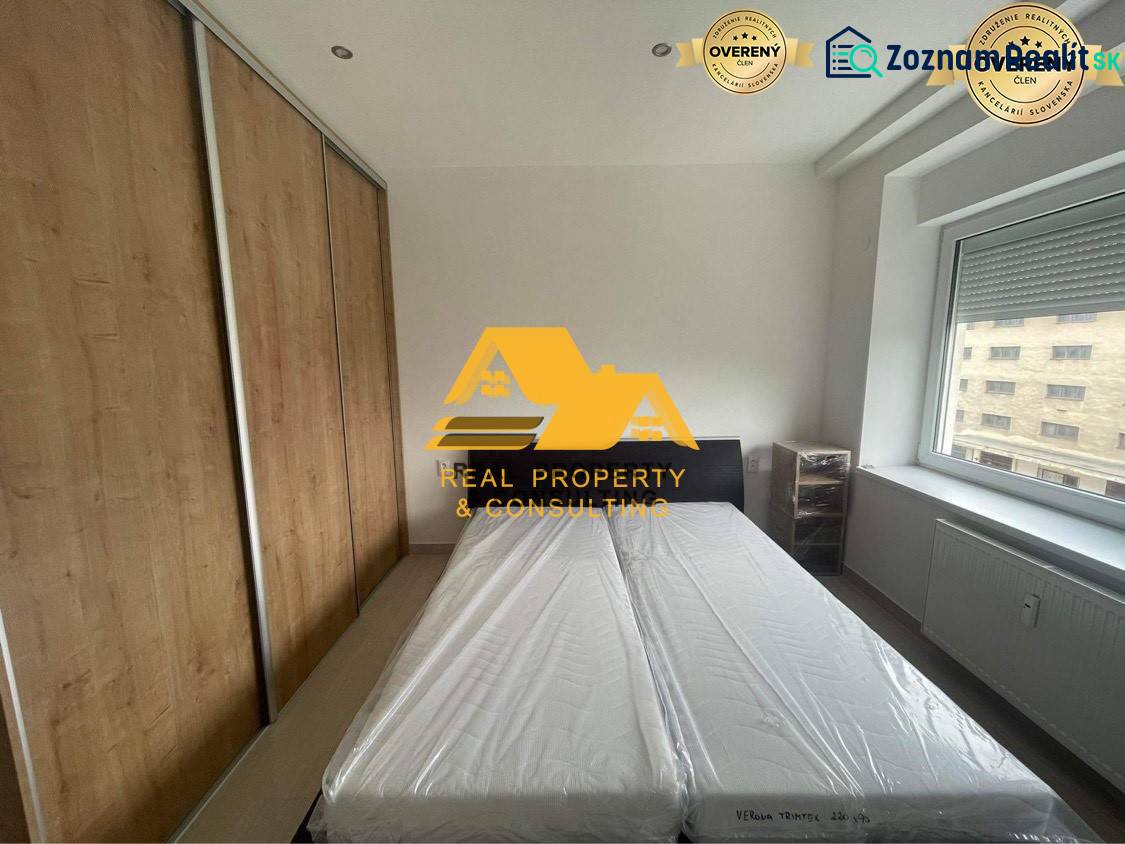 Schlafzimmer in einer 3-Zimmer-Wohnung mit Bett, Einbauschrank und Fenster mit Aussicht.